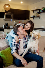 couple sitting on sofa with dog