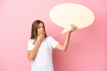 Young Lithuanian woman isolated on pink background holding an empty speech bubble with surprised expression