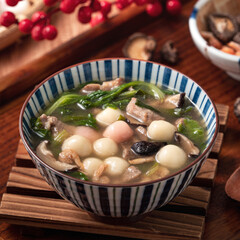 Red and white tangyuan with savory soup.