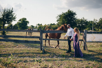 A loving couple on a date. Horseback riding. Purple dress.