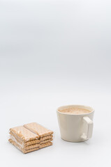 delicious hot vegan Cappuccino with foam in a white cup and packaged biscuits on a white background