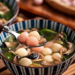 Red and white tangyuan with savory soup.
