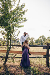 Couple on a date. Purple dress. Bride and groom. Walk in the field. Love story.