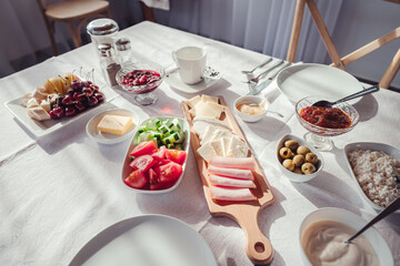 Continental breakfast with an assortment of snacks on a snow-white tablecloth on a set table at the hotel