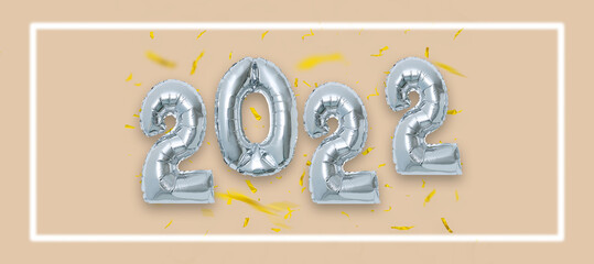 silver color Christmas 2022 balloons isolated on orange background