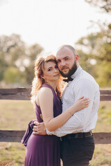 Couple on a date. Purple dress. Bride and groom. Walk in the field. Love story.