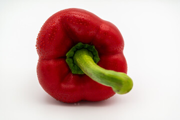 A fresh red paprika lying on the side on a white background.