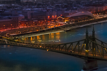 The magic panorama of the city at dusk, river, bridge and city lights. Budapest at night Hungary, tilt-shift effect, toned