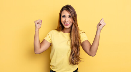 asian pretty woman feeling happy, positive and successful, celebrating victory, achievements or...