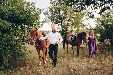 A loving couple on a date. Horseback riding. Purple dress.