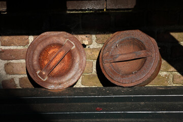 A close-up of the rusty lids of old milk cans
