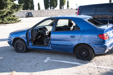 abandoned car in the middle of a car park. problem of abandoned waste not being processed as recycling.