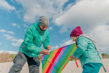 Father with his 5 years old daughter prepairing kite to fly