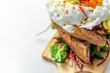 Egg in a cloud on grilled sandwiches with cumberland sausage, tomato and mayonnaise, all served with a fresh salad