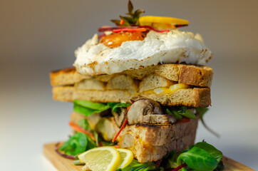 Egg in a cloud on grilled sandwiches with cumberland sausage, tomato and mayonnaise, all served with a fresh salad