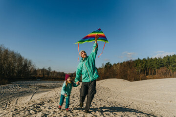 Father with his 5 years old daughter prepairing kite to fly