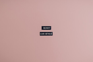 Wishes words Merry Christmas spelled black with embossed label maker. New Year minimal card concept and idea for diy holiday decoration. Flat lay with negative copy space.