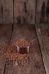 Buckwheat in a measuring glass on a wooden background