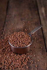 Buckwheat in a measuring glass on a wooden background