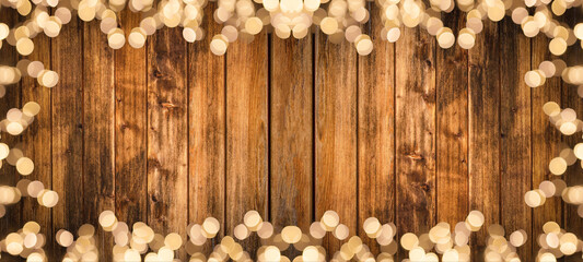 Frame of lights bokeh golden flares, isolated on rustic brown wooden texture - Holiday New Year's Eve Silvester New Year Party Christmas festive background banner panorama greeting card..