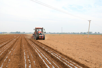Farmers use planters to plant plastic coated peanuts on farms, North China