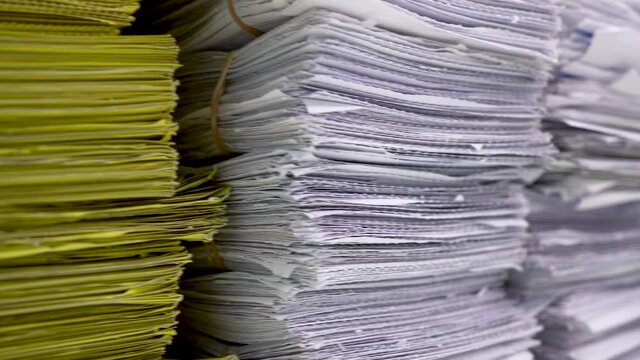 Stack of yellow and white documents on the desktop in the office.
