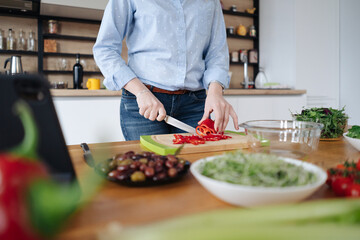 Obraz na płótnie Canvas Closeup of human hands cooking vegetables salad in kitchen