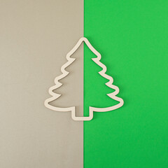 white frame in the shape of a christmas tree against grey and green background. copy space background. template. retro minimalism
