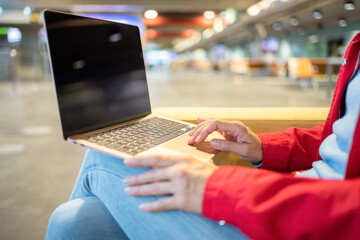 Anonymous woman typing on laptop in airport