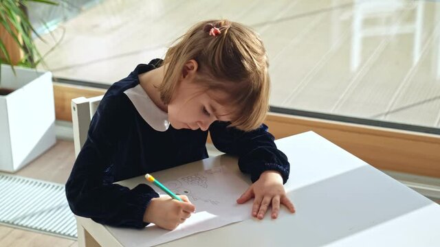 Elementary Public School Smart Creative Focused Young Caucasian Girl Student Drawing Picture with Pencil on White Sheet of Paper Wearing Elegant School Uniform