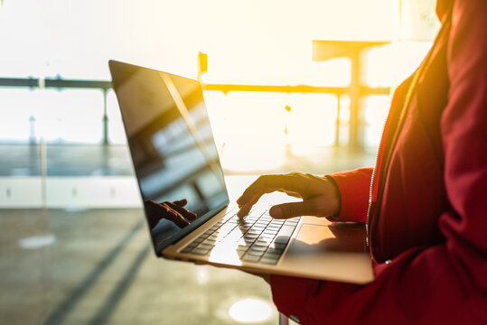 Faceless traveler browsing laptop in airport