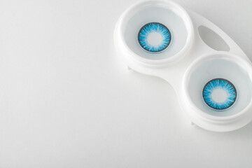 Colored contact lenses in a container. Close-up, gray background. Eye color change. Copy Space