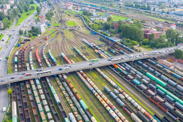 Railway marshalling yard and road bridge above it with cars. Import and export logistics....