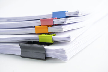 Stack of report paper files in business office clips.
