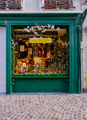 Exterior view of a Christmas gift in Belgium. Green Christmas store full whit toys in Brussel. Belgian Christmas gift shop window. Traditional Belgian architecture of a Christmas store. 