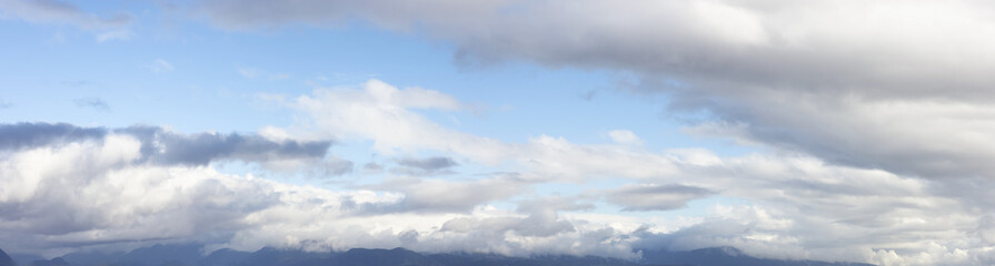 Fototapeta premium Beautiful Panoramic View of Cloudscape during a colorful and sunny fall season day. Taken on the West Coast of British Columbia, Canada.