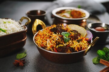 Indian veg non veg meal thali - mutton biryani, raita, malai kofta, basmati rice,  and gulab jamun, selective focus