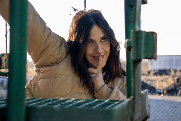 cheerful and friendly young brunette woman making expressive faces on the gangway of a freight...