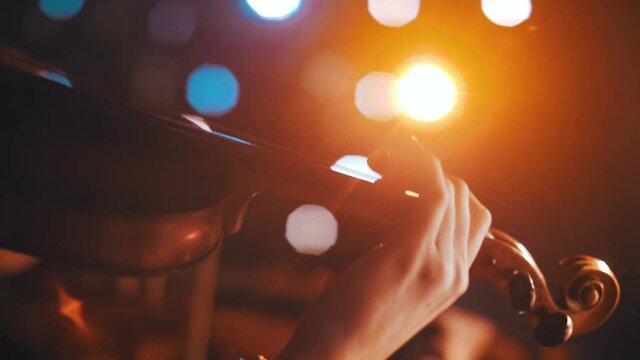 A woman playing the violin in the theatre. Close-up.