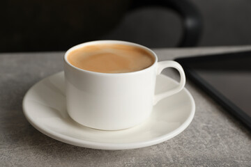 Fototapeta na wymiar Coffee Break at workplace. Cup of hot drink on grey table