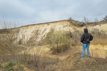 Portrait of pretty slim woman standing in front of sand quarry, freedom
