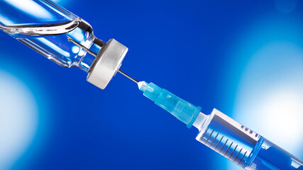 The syringe with the needle takes up the contents of the ampoule. Vaccination concept. 