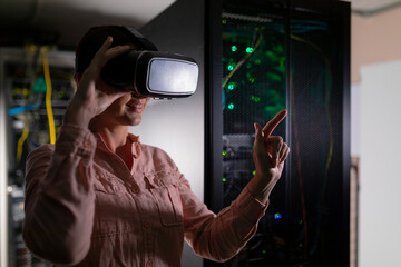 Caucasian woman wearing vr headset touching an invisible screen in computer server room