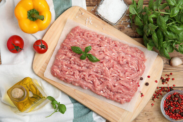 Raw chicken minced meat and ingredients on wooden table, flat lay