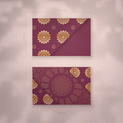Burgundy business card with antique gold ornaments for your contacts.
