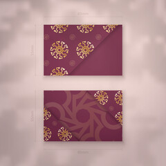 Burgundy business card with Greek gold pattern for your contacts.