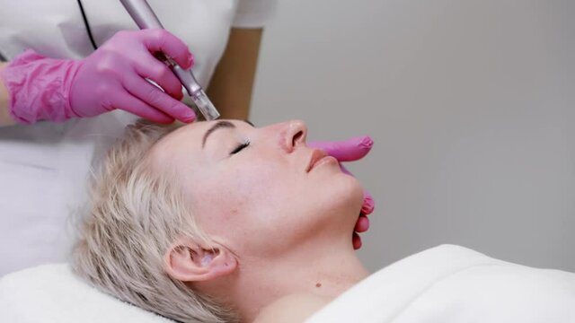 Anti-aging treatment. Close up portrait of adult woman at a mesotherapy procedure in cosmetology clinic.
