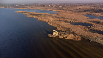 Aerial shot of church and fortification castle located on river coast.