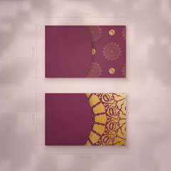 Burgundy business card with vintage gold ornaments for your business.
