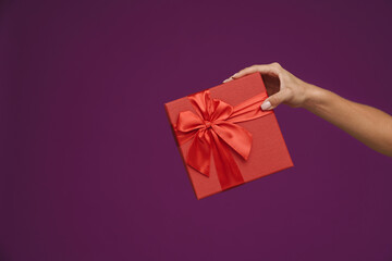 Photo of woman's hand showing red gift box
